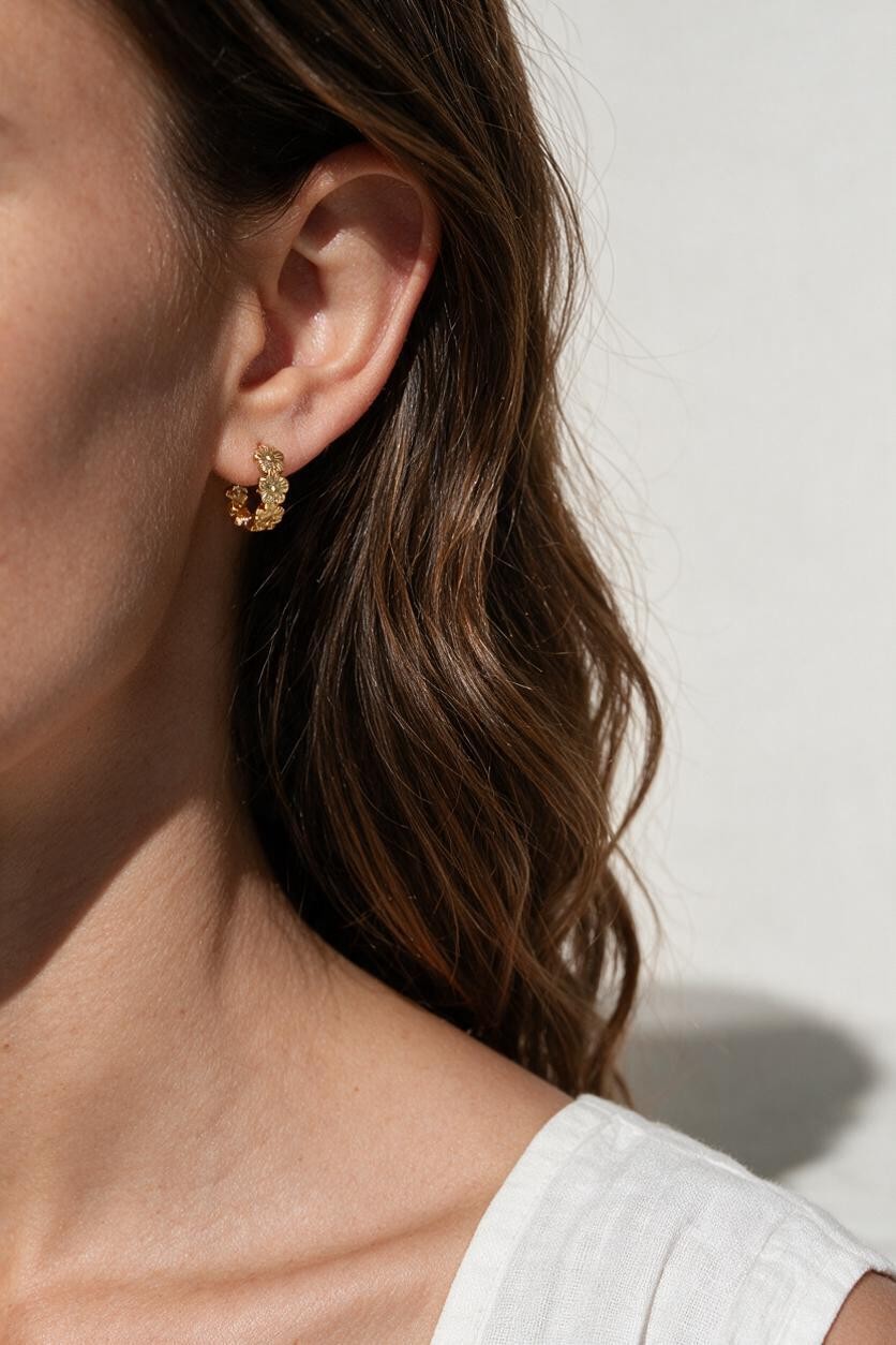 gold flower huggie hoop earrings on model, daisy hoop earrings, floral huggie earrings, small gold flower hoops, textured flower earrings, dainty floral hoops, garden jewelry, nature-inspired earrings, gold huggie earrings, spring floral jewelry, bridesmaid gift, gift for her