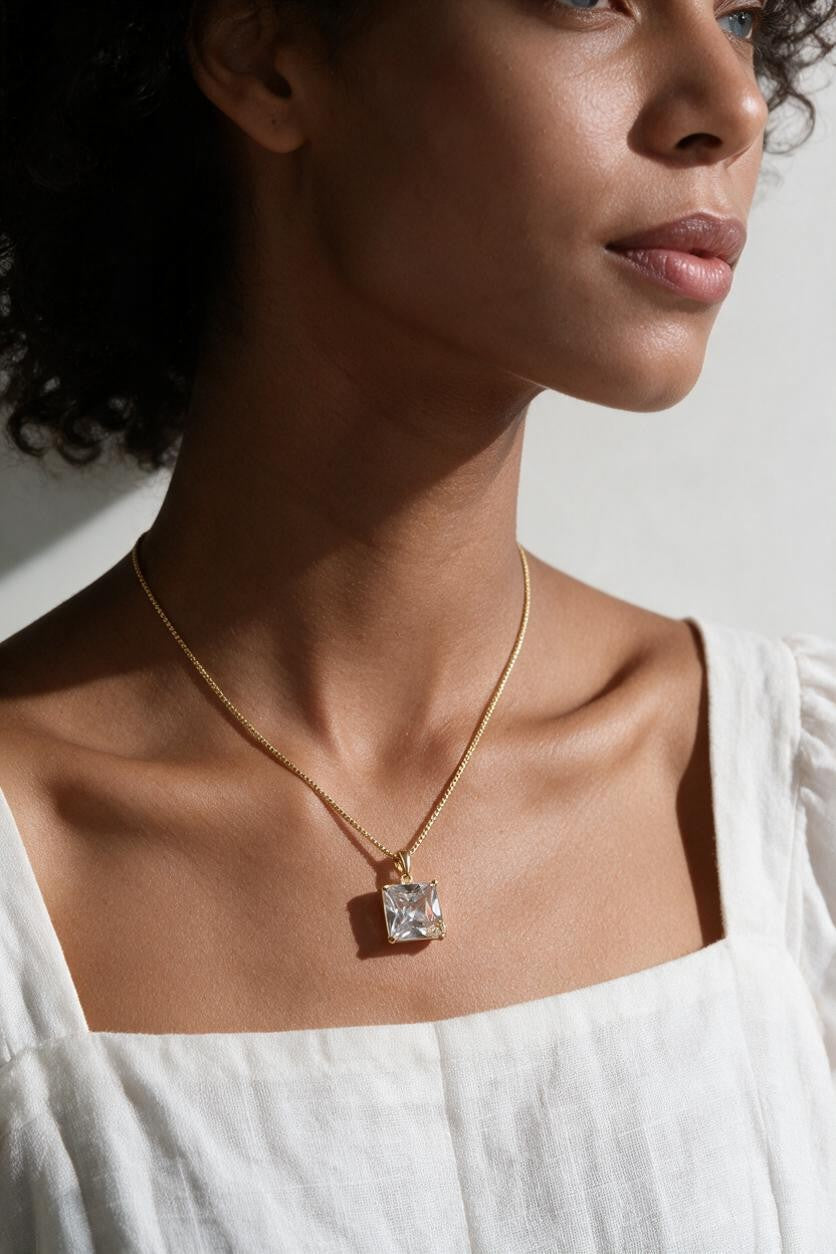 princess cut necklace on model, crystal solitaire pendant lifestyle, gold box chain necklace, square cut crystal necklace, statement pendant on model, layering necklace jewelry
