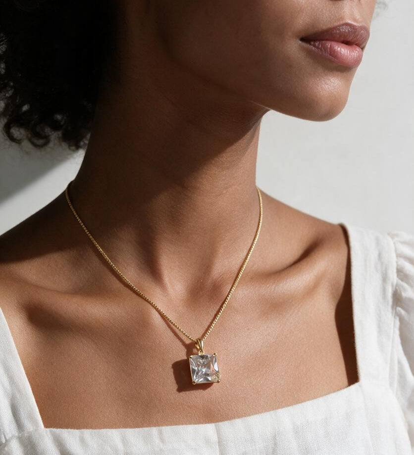 princess cut necklace on model, crystal solitaire pendant lifestyle, gold box chain necklace, square cut crystal necklace, statement pendant on model, layering necklace jewelry