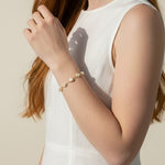 pearl charm bracelet, pearl bracelet on model, gold chain pearl bracelet with charm, dainty pearl bracelet, layering pearl bracelet, pearl bracelet lifestyle, pearl bracelet dangle detail, everyday pearl bracelet