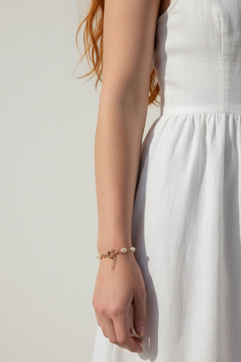 pearl charm bracelet, pearl bracelet on model, gold chain pearl bracelet with charm, dainty pearl bracelet, layering pearl bracelet, pearl bracelet lifestyle, pearl bracelet dangle detail, everyday pearl bracelet