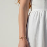 pearl charm bracelet, pearl bracelet on model, gold chain pearl bracelet with charm, dainty pearl bracelet, layering pearl bracelet, pearl bracelet lifestyle, pearl bracelet dangle detail, everyday pearl bracelet