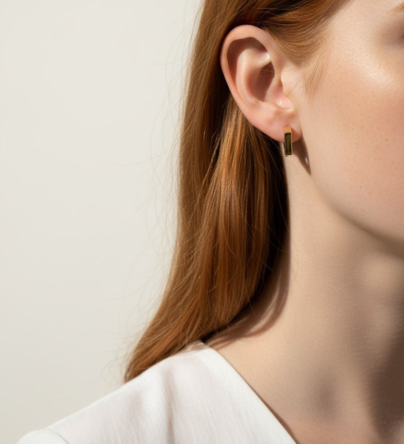 square huggie hoop earrings on model, gold geometric earrings worn, modern hoop earrings lifestyle, angular gold hoops styled, polished square earrings, minimalist huggie earrings, statement gold hoops, architectural earrings on ear