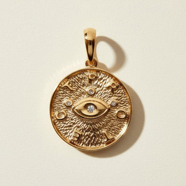 protected pendant, evil eye coin necklace, gold word pendant, medallion pendant gold, symbolic jewelry, textured gold pendant, protective jewelry, layering pendant