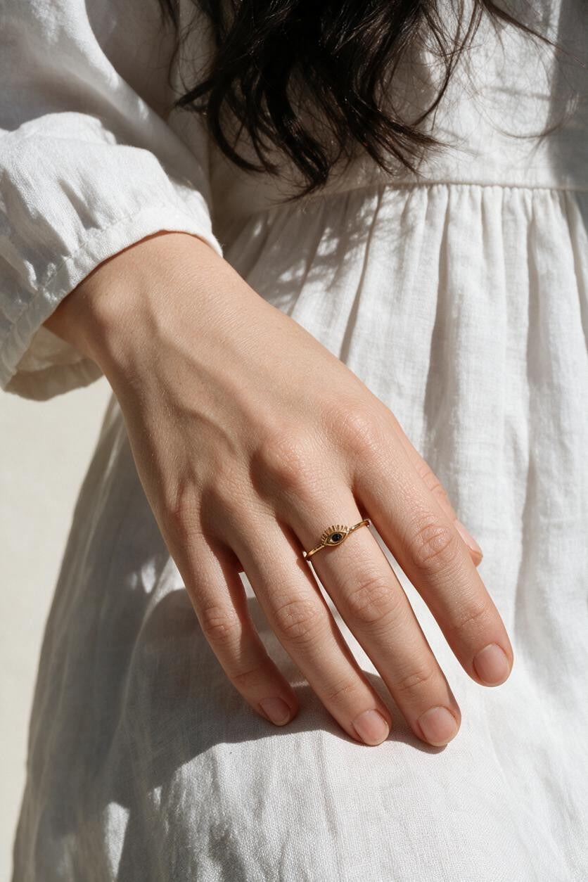 eye ring on model, evil eye ring on hand, dainty gold eye ring, blue stone eye ring lifestyle, minimalist stacking ring, lash eye ring styled, protective eye jewelry