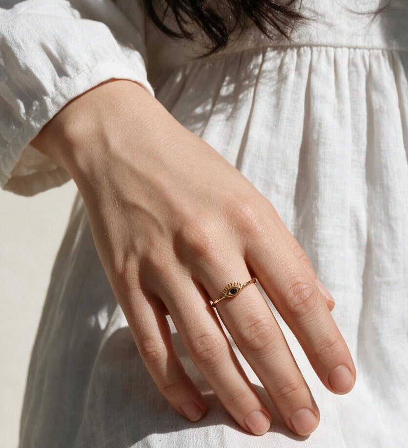eye ring on model, evil eye ring on hand, dainty gold eye ring, blue stone eye ring lifestyle, minimalist stacking ring, lash eye ring styled, protective eye jewelry