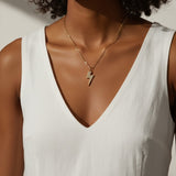lightning bolt pendant necklace, pave crystal lightning bolt, gold bolt charm necklace, figaro chain necklace, statement pendant detail, crystal encrusted pendant, edgy gold necklace, lightning bolt jewelry
