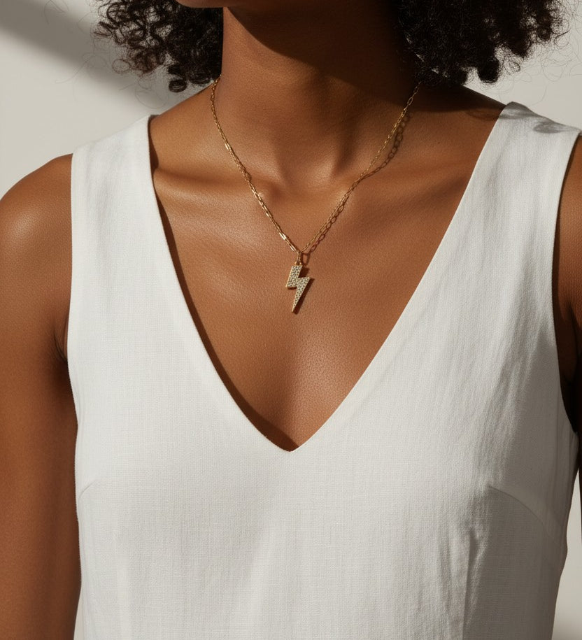 lightning bolt pendant necklace, pave crystal lightning bolt, gold bolt charm necklace, figaro chain necklace, statement pendant detail, crystal encrusted pendant, edgy gold necklace, lightning bolt jewelry