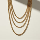 curb chain necklace flat lay, gold curb link necklace detail, classic chain necklace, layered chain necklace, clasp detail necklace, polished chain necklace, gold link necklace, layering necklace set