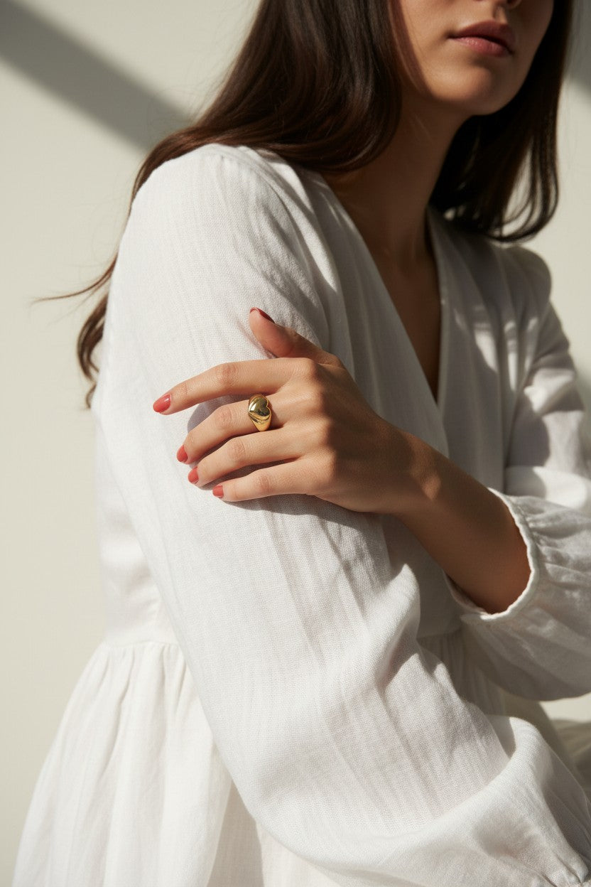 heart signet ring on model, gold heart ring lifestyle, chunky heart ring styled, adjustable open ring on hand, textured gold ring outfit, dome band heart ring, statement heart jewelry, romantic gold ring