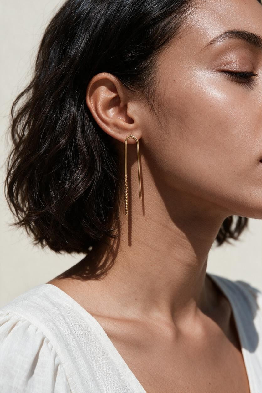 gold U-shaped drop earrings on model, long gold bar earrings, hairpin earrings, elongated arch earrings, beaded drop earrings, minimalist gold earrings, modern statement earrings, linear drop earrings, earrings for short hair, lightweight gold earrings, gift for her, editorial jewelry