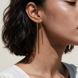 gold U-shaped drop earrings on model, long gold bar earrings, hairpin earrings, elongated arch earrings, beaded drop earrings, minimalist gold earrings, modern statement earrings, linear drop earrings, earrings for short hair, lightweight gold earrings, gift for her, editorial jewelry