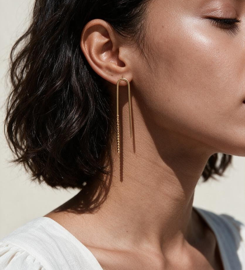 gold U-shaped drop earrings on model, long gold bar earrings, hairpin earrings, elongated arch earrings, beaded drop earrings, minimalist gold earrings, modern statement earrings, linear drop earrings, earrings for short hair, lightweight gold earrings, gift for her, editorial jewelry