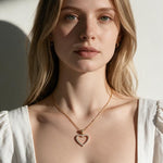 heart necklace on model, pavé heart pendant lifestyle, open heart necklace styled, crystal heart necklace editorial, gold heart pendant on neck, romantic layering necklace