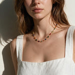 rainbow station necklace on model, colorful gemstone necklace, multicolor bezel necklace, gold station necklace, dainty colorful necklace, jewel tone necklace, emerald cut crystal necklace, summer layering necklace, collarbone length necklace, minimalist color necklace, white linen outfit jewelry, women’s rainbow necklace