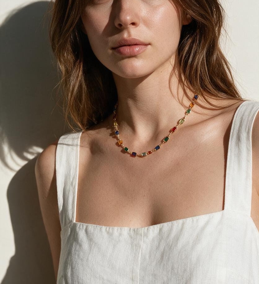 rainbow station necklace on model, colorful gemstone necklace, multicolor bezel necklace, gold station necklace, dainty colorful necklace, jewel tone necklace, emerald cut crystal necklace, summer layering necklace, collarbone length necklace, minimalist color necklace, white linen outfit jewelry, women’s rainbow necklace