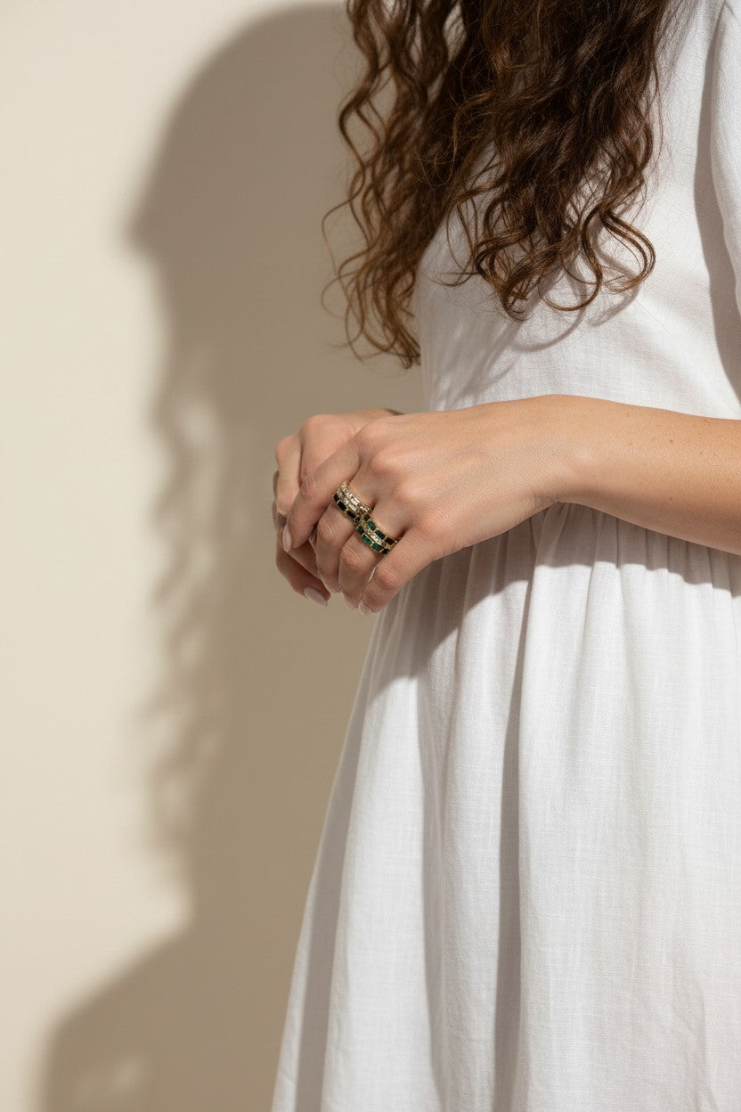 baguette eternity ring stack, gold eternity bands on model, stacked statement rings, emerald and black ring stack, layered baguette rings, gold ring stack lifestyle, colorful eternity bands worn, multi-stone ring stack