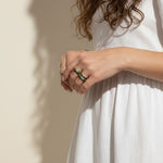 baguette eternity ring stack, gold eternity bands on model, stacked statement rings, emerald and black ring stack, layered baguette rings, gold ring stack lifestyle, colorful eternity bands worn, multi-stone ring stack