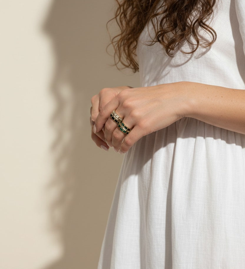 baguette eternity ring stack, gold eternity bands on model, stacked statement rings, emerald and black ring stack, layered baguette rings, gold ring stack lifestyle, colorful eternity bands worn, multi-stone ring stack