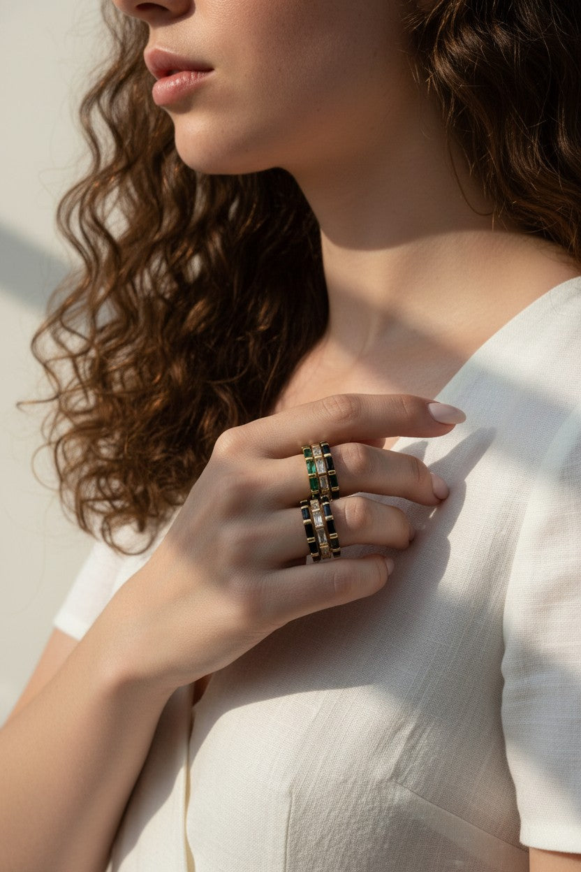 baguette eternity ring stack, gold eternity bands on model, stacked statement rings, emerald and black ring stack, layered baguette rings, gold ring stack lifestyle, colorful eternity bands worn, multi-stone ring stack