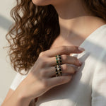 baguette eternity ring stack, gold eternity bands on model, stacked statement rings, emerald and black ring stack, layered baguette rings, gold ring stack lifestyle, colorful eternity bands worn, multi-stone ring stack