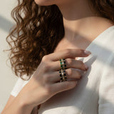 baguette eternity ring stack, gold eternity bands on model, stacked statement rings, emerald and black ring stack, layered baguette rings, gold ring stack lifestyle, colorful eternity bands worn, multi-stone ring stack