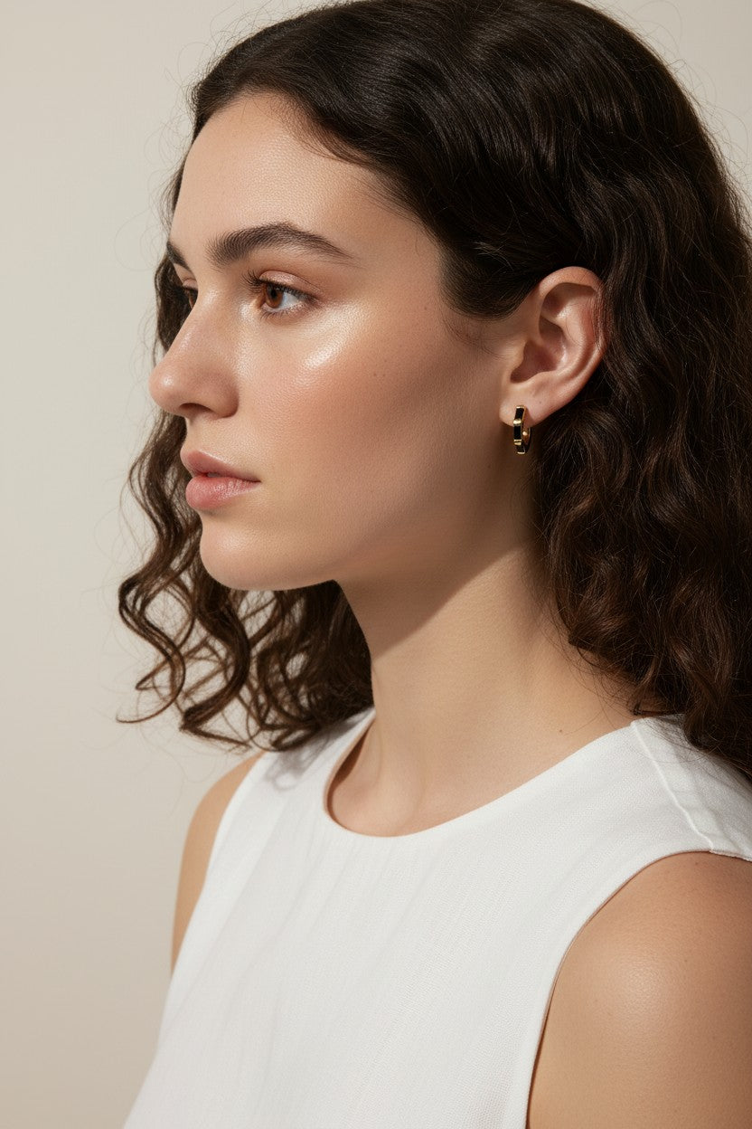 gold baguette hoops on model, huggie hoop earrings worn, emerald huggie hoop earrings, black baguette hoop earrings, clear crystal huggie hoops, gold hoop earrings colorways, baguette stone earrings styled, small gold hoops on ear