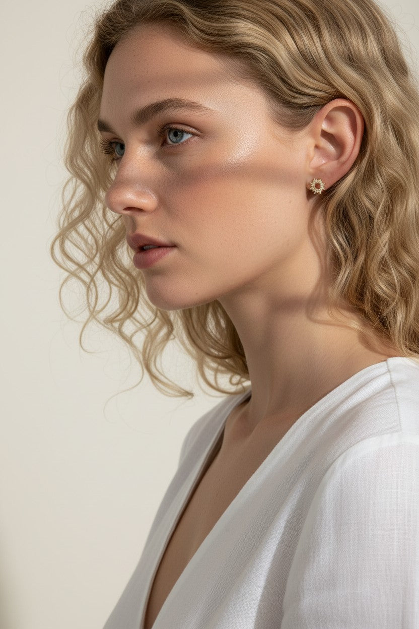 gold sunburst earrings on model, pavé starburst stud earrings, celestial stud earrings worn, gold star stud earring close-up, dainty gold stud earrings, cubic zirconia sun earrings, everyday gold stud earrings