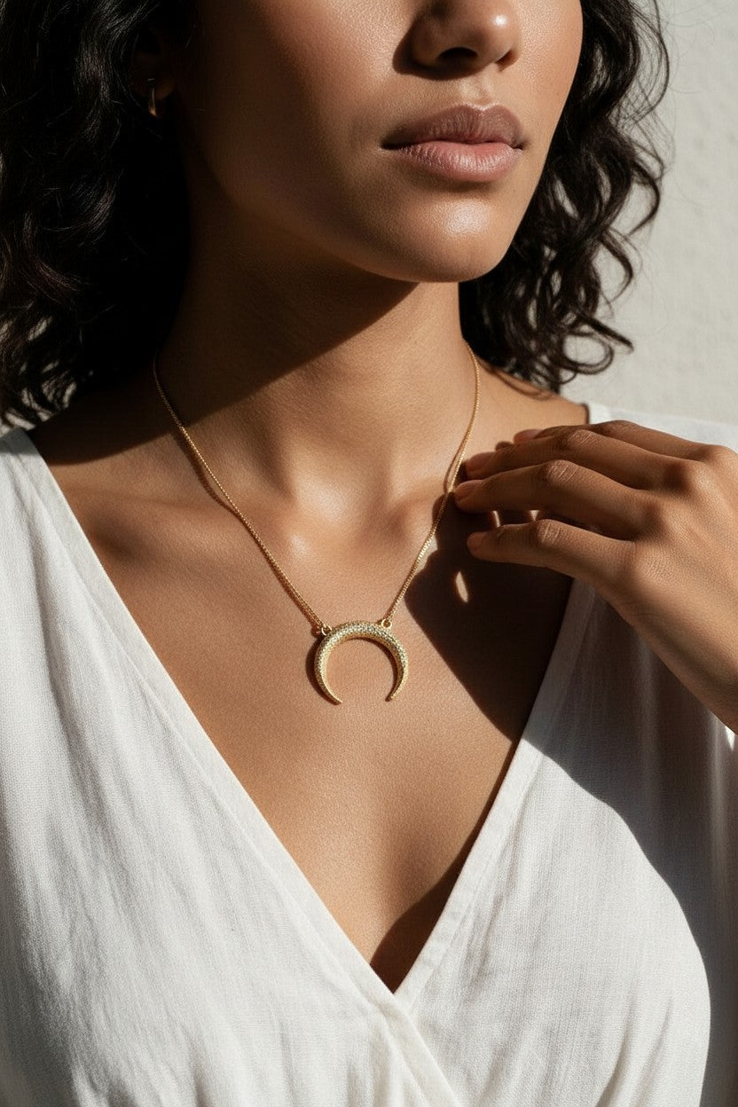 crescent moon necklace, pavé horn pendant, gold crescent necklace, celestial pendant necklace, moon horn necklace on model, dainty crescent jewelry, crystal crescent necklace