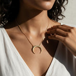 crescent moon necklace, pavé horn pendant, gold crescent necklace, celestial pendant necklace, moon horn necklace on model, dainty crescent jewelry, crystal crescent necklace