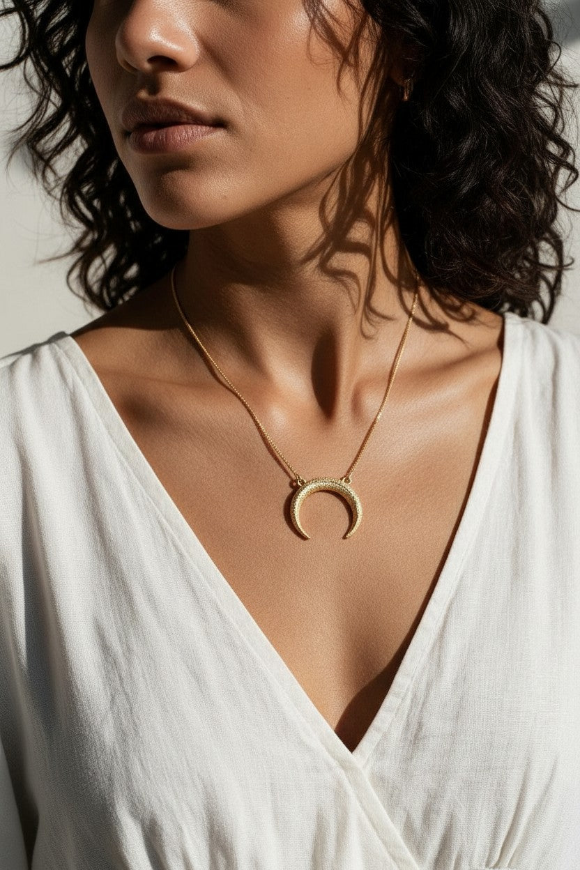 crescent moon necklace, pavé horn pendant, gold crescent necklace, celestial pendant necklace, moon horn necklace on model, dainty crescent jewelry, crystal crescent necklace