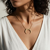 crescent moon necklace, pavé horn pendant, gold crescent necklace, celestial pendant necklace, moon horn necklace on model, dainty crescent jewelry, crystal crescent necklace