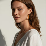 classic gold hoop earrings on model, gold tube hoop earrings, polished gold hoops, medium gold hoop earrings, thick gold hoops, everyday gold hoops, timeless hoop earrings, minimalist gold hoops, lightweight chunky hoops, hoop earrings for long hair, gift for her, summer linen style jewelry