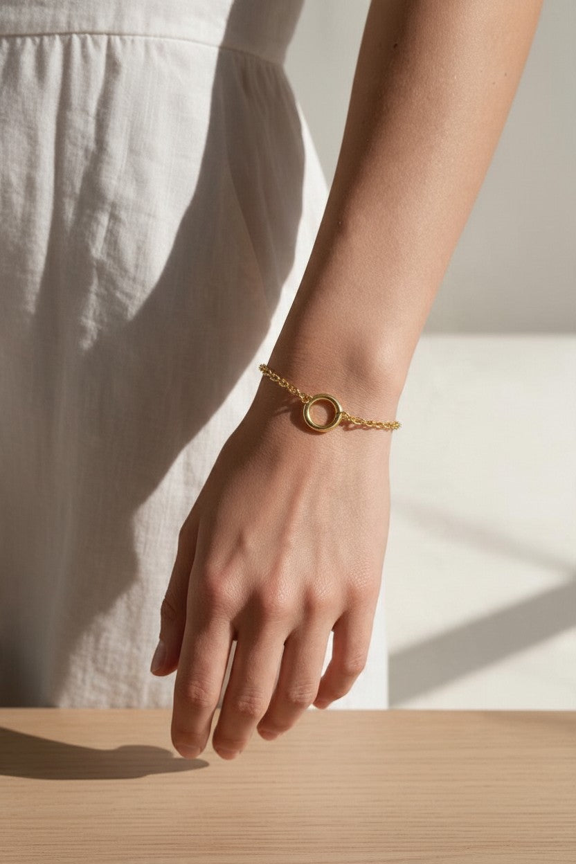 gold rolo chain bracelet on wrist, round clasp bracelet, charm holder bracelet, spring ring clasp bracelet, gold chain bracelet with ring, minimalist gold bracelet, modern gold bracelet, layering bracelet, everyday gold bracelet, interchangeable charm bracelet, circle clasp bracelet, women’s gold bracelet