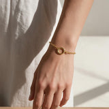 gold rolo chain bracelet on wrist, round clasp bracelet, charm holder bracelet, spring ring clasp bracelet, gold chain bracelet with ring, minimalist gold bracelet, modern gold bracelet, layering bracelet, everyday gold bracelet, interchangeable charm bracelet, circle clasp bracelet, women’s gold bracelet