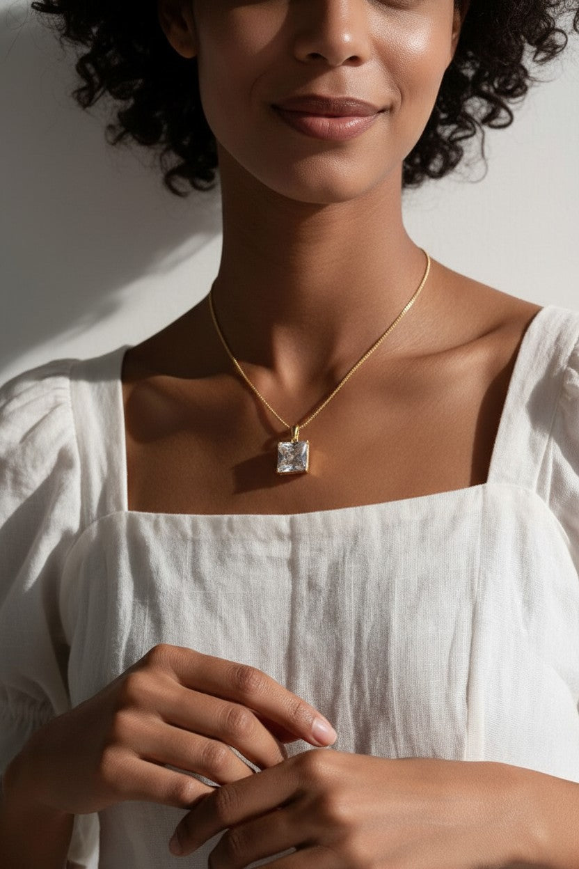 princess cut necklace on model, crystal solitaire pendant lifestyle, gold box chain necklace, square cut crystal necklace, statement pendant on model, layering necklace jewelry
