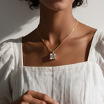princess cut necklace on model, crystal solitaire pendant lifestyle, gold box chain necklace, square cut crystal necklace, statement pendant on model, layering necklace jewelry