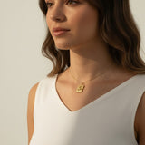 tulip pendant necklace on model, gold flower tag necklace lifestyle, botanical pendant necklace worn, engraved tulip necklace styled, dainty gold necklace on neck, CZ accent pendant, nature-inspired jewelry, rope-edge tag necklace