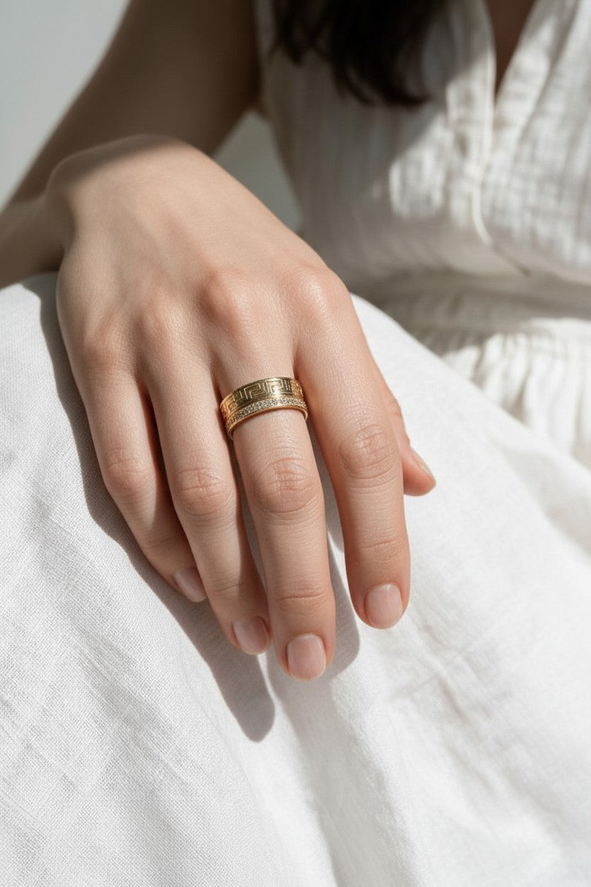 Greek key ring on model, wide gold band ring on hand, meander pattern ring, pavé band ring lifestyle, engraved gold statement ring, geometric gold band styled