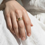 Greek key ring on model, wide gold band ring on hand, meander pattern ring, pavé band ring lifestyle, engraved gold statement ring, geometric gold band styled