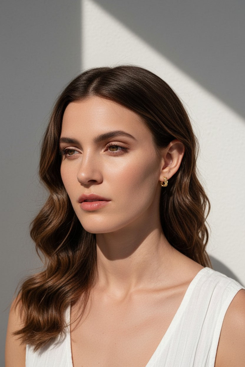 gold flower huggie hoop earrings on model, daisy hoop earrings, floral huggie earrings, small gold flower hoops, textured flower earrings, dainty floral hoops, garden jewelry, nature-inspired earrings, gold huggie earrings, spring floral jewelry, bridesmaid gift, gift for her