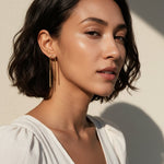 gold U-shaped drop earrings on model, long gold bar earrings, hairpin earrings, elongated arch earrings, beaded drop earrings, minimalist gold earrings, modern statement earrings, linear drop earrings, earrings for short hair, lightweight gold earrings, gift for her, editorial jewelry