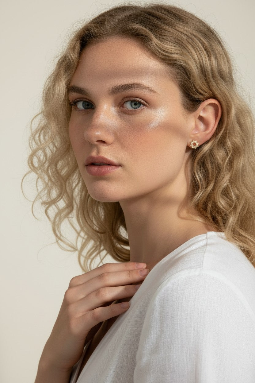 gold sunburst earrings on model, pavé starburst stud earrings, celestial stud earrings worn, gold star stud earring close-up, dainty gold stud earrings, cubic zirconia sun earrings, everyday gold stud earrings
