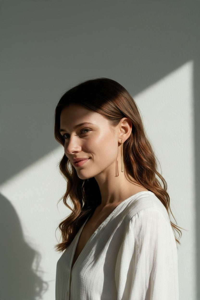 long gold rectangle earrings on model, geometric wire earrings, minimalist gold drop earrings, elongated open hoop earrings, modern gold earrings, lightweight statement earrings, architectural earrings, thin gold wire earrings, contemporary gold jewelry, linear gold earrings, women’s geometric earrings, elegant everyday earrings