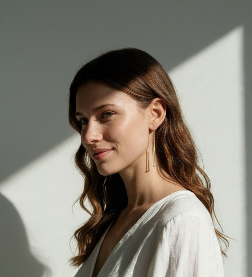 long gold rectangle earrings on model, geometric wire earrings, minimalist gold drop earrings, elongated open hoop earrings, modern gold earrings, lightweight statement earrings, architectural earrings, thin gold wire earrings, contemporary gold jewelry, linear gold earrings, women’s geometric earrings, elegant everyday earrings