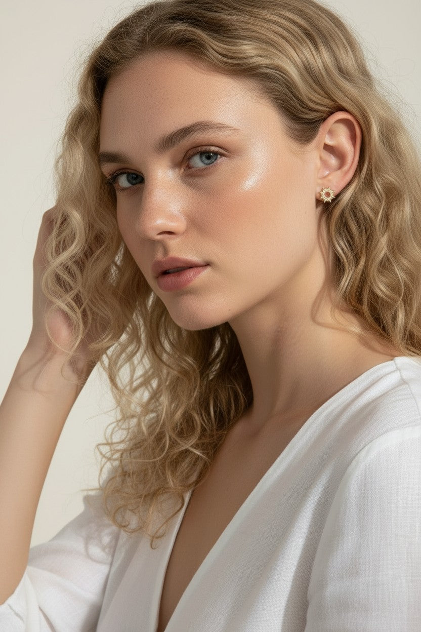 gold sunburst earrings on model, pavé starburst stud earrings, celestial stud earrings worn, gold star stud earring close-up, dainty gold stud earrings, cubic zirconia sun earrings, everyday gold stud earrings