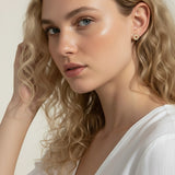 gold sunburst earrings on model, pavé starburst stud earrings, celestial stud earrings worn, gold star stud earring close-up, dainty gold stud earrings, cubic zirconia sun earrings, everyday gold stud earrings