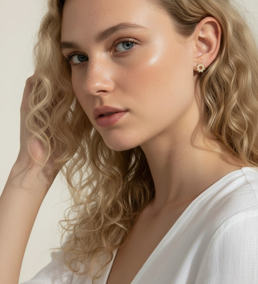 gold sunburst earrings on model, pavé starburst stud earrings, celestial stud earrings worn, gold star stud earring close-up, dainty gold stud earrings, cubic zirconia sun earrings, everyday gold stud earrings