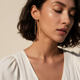 gold U-shaped drop earrings on model, long gold bar earrings, hairpin earrings, elongated arch earrings, beaded drop earrings, minimalist gold earrings, modern statement earrings, linear drop earrings, earrings for short hair, lightweight gold earrings, gift for her, editorial jewelry