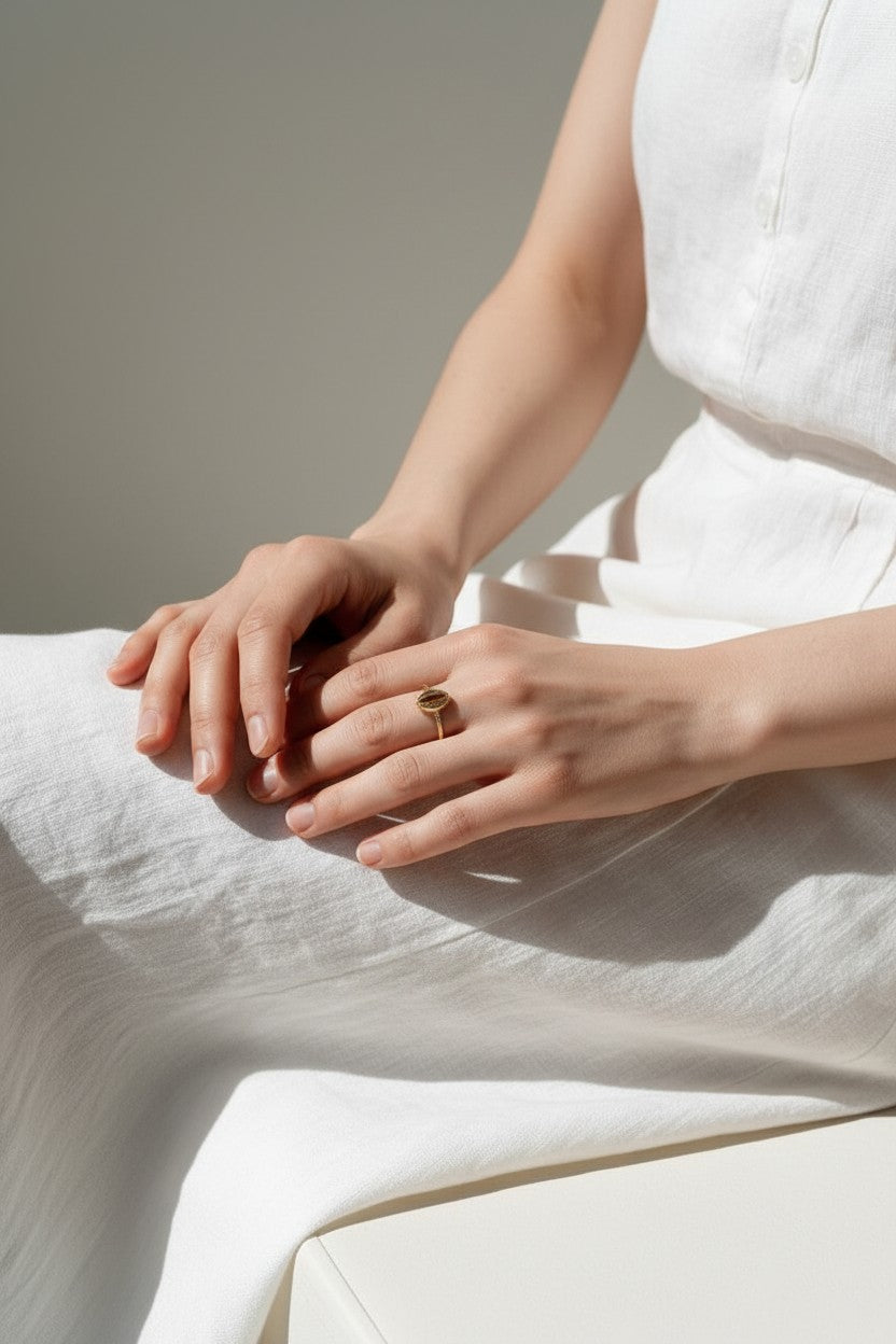 cowrie shell ring on model, gold cowrie ring on hand, shell motif ring, dainty gold ring lifestyle, minimalist stacking ring, beach jewelry ring styled, cowrie jewelry